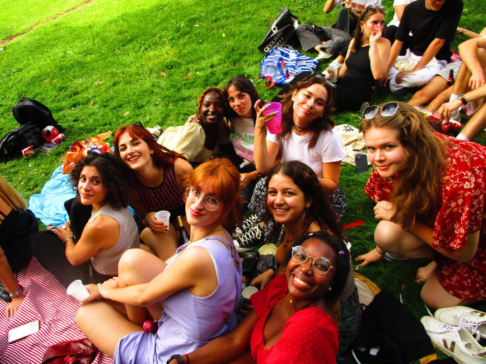 A group of women sitting on the grass

Description automatically generated